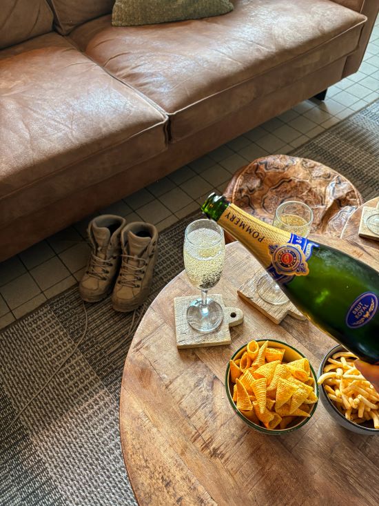 hiking shoes in the back and some glasses and snacks in the front in the living room of a holiday house