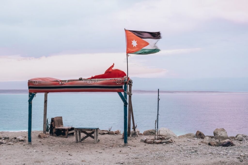 flag of jardin in the wind with the dead sea in the background