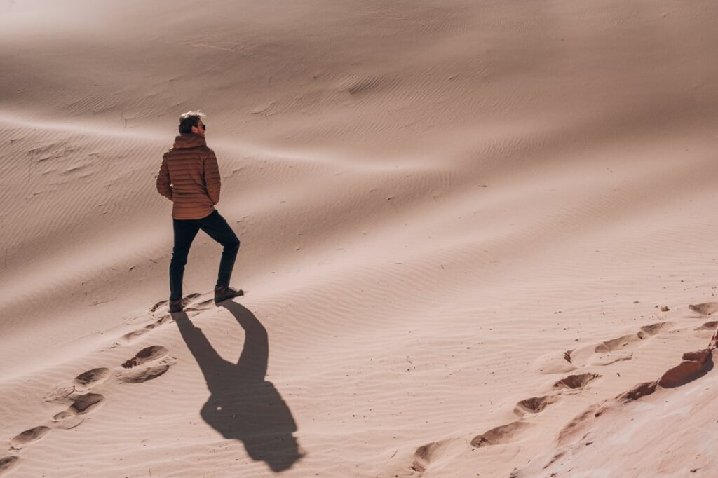 Matthias climbing sand dune with warm jacket