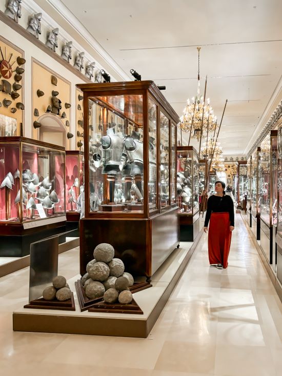 Mieke walking in a room that is filled with displays with armour