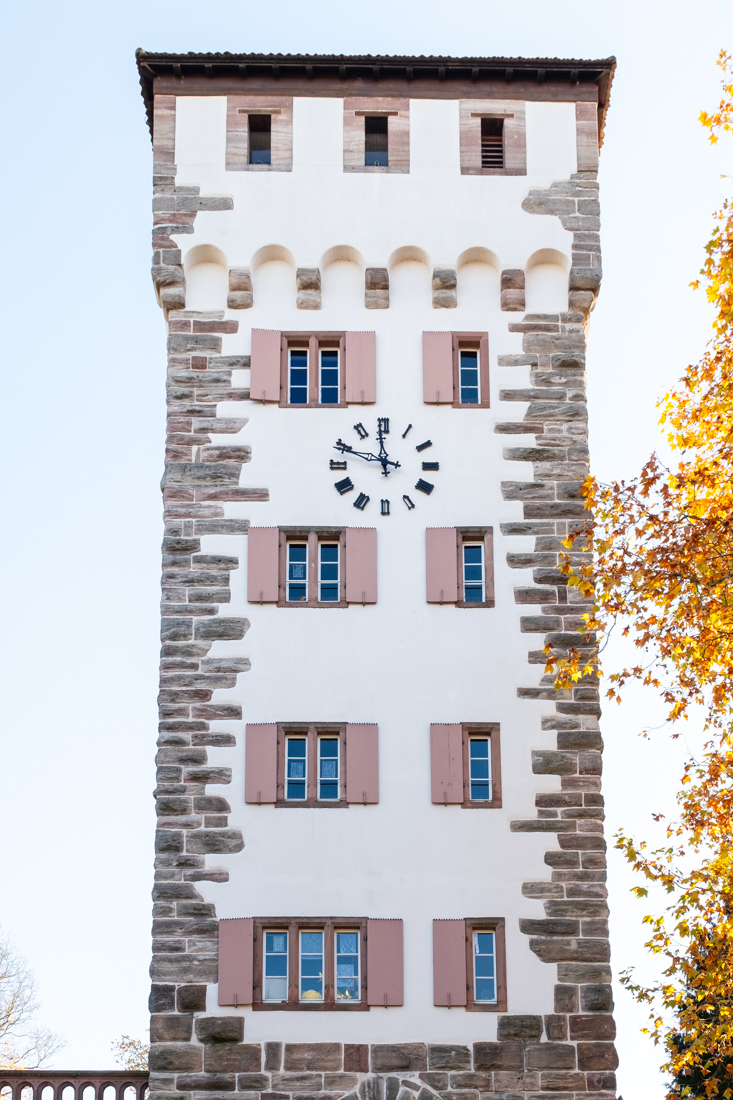 The white tower of St. Alban in Basel, with pink window fronts