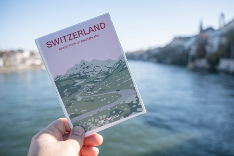 Handholding the map of the Grand Tour of Switzerland, against the Rhine river as a background
