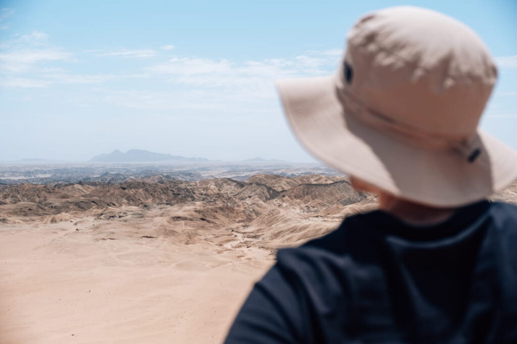 Matthias in a beige sun hat looking over the rugged Moon Valley canyons in the Namib Desert, Namibia.